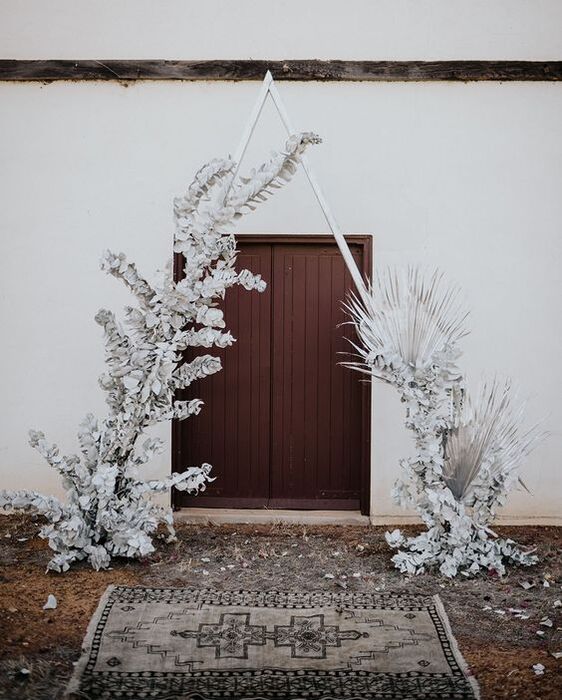 All-white wedding decor with a Triangle Arch Backdrop