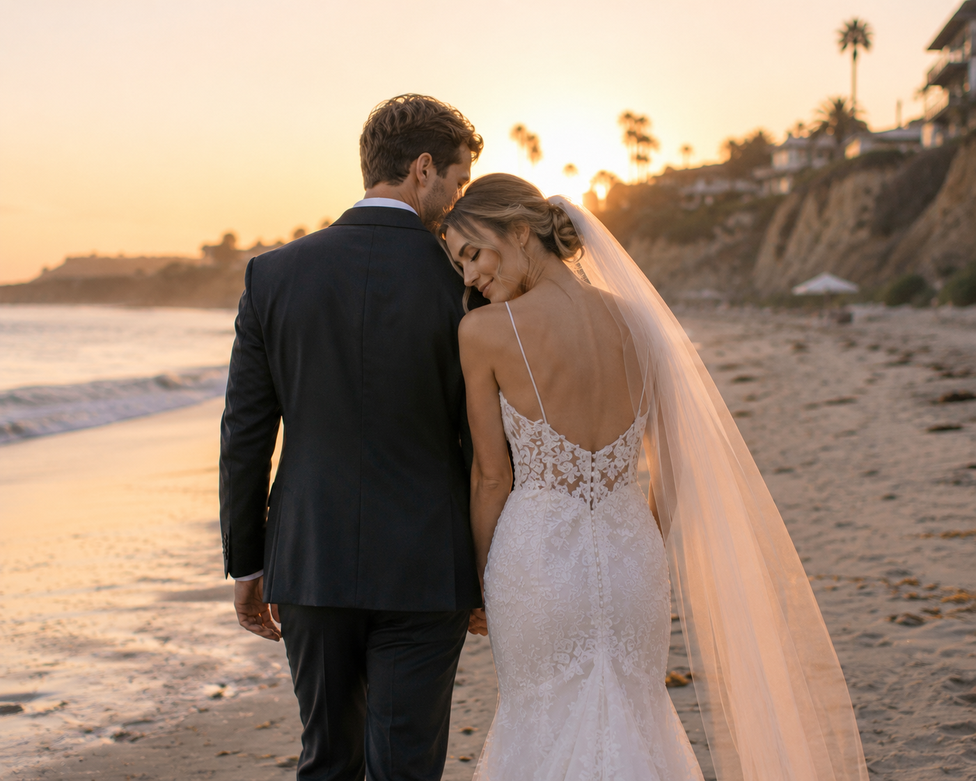Tips for Posing Naturally on Your Wedding Day 2026 10 Bride resting her head on the groom’s shoulder while walking along a sandy California beach at sunset
